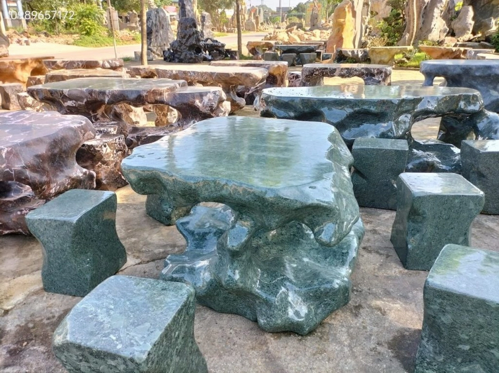 Bộ bàn ghế đá tự nhiên đặt giữa không gian sân vườn tạo điểm nghỉ chân mộc mạc