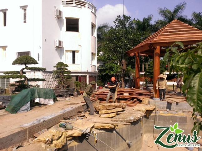 Công trình hồ Koi hoàn thiện với bờ đá, cây xanh và mặt nước phản chiếu ánh sáng dịu