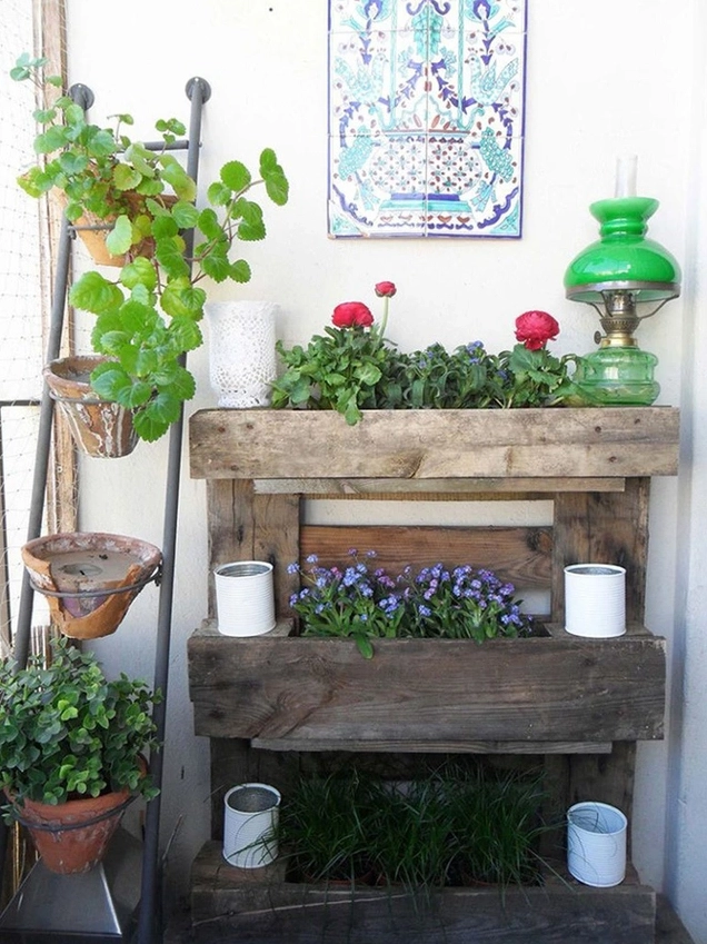 Góc sân vườn dùng gỗ pallet làm điểm nhấn mộc mạc giữa mảng cây xanh tươi