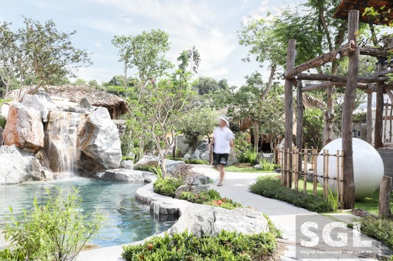 Góc sân vườn Hồ Cốc Coffee Safari có cây xanh nhiệt đới ôm lấy lối đi và không gian nghỉ chân