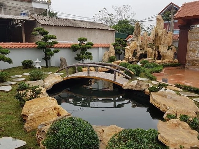 Hồ cá Koi biệt thự được bo viền đá tự nhiên bên cạnh mảng xanh sân vườn