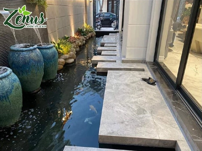 Hồ cá Koi hiện đại với mặt nước trong xanh và đường nét thiết kế gọn gàng giữa sân vườn