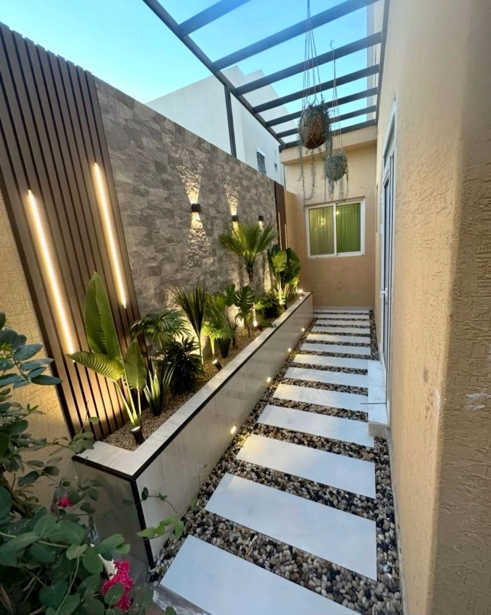 Mẫu thiết kế sân vườn bên hông nhà đẹp với sắc xanh nổi bật trên nền vật liệu tự nhiên