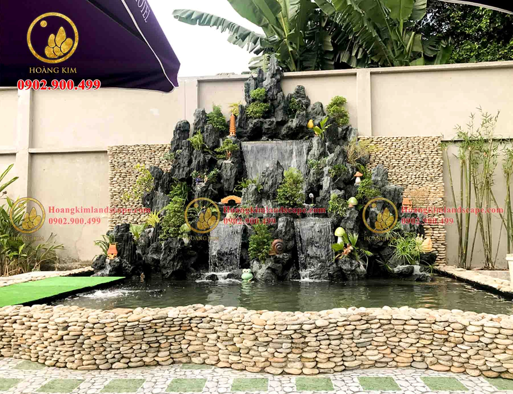 Tiểu cảnh hòn non bộ trong quán cà phê nhà hàng với cây xanh và đá nước gần gũi