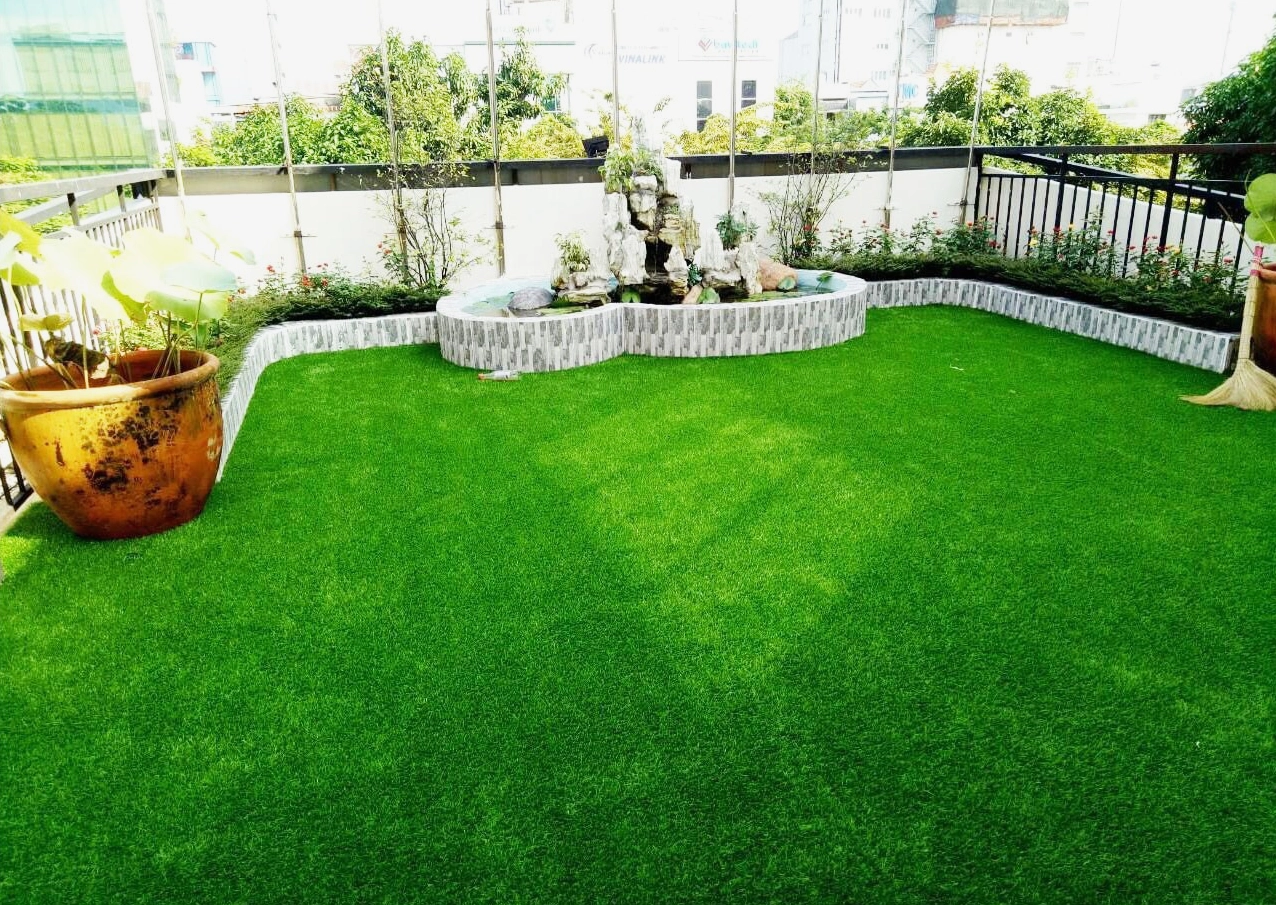 Ý tưởng trang trí sân vườn bằng cỏ nhân tạo với màu xanh tươi và bề mặt gọn sạch